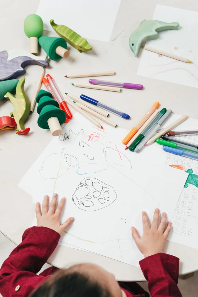 Child drawing with dark crayons at a kitchen table, a common moment that leaves parents wondering what it means Child drawing with dark crayons at a kitchen table, a common moment that leaves parents wondering what it means