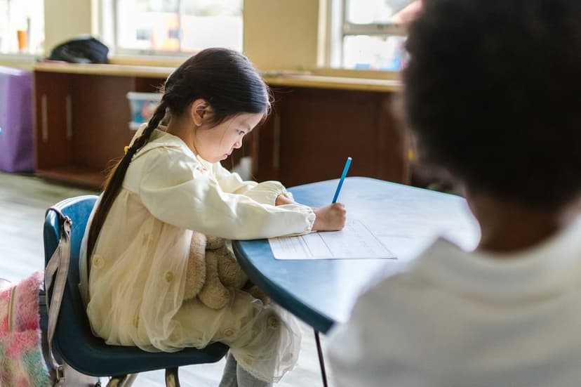 Elementary-aged child gripping a pencil tightly while writing at a desk, illustrating handwriting difficulty and possible dysgraphia Elementary-aged child gripping a pencil tightly while writing at a desk, illustrating handwriting difficulty and possible dysgraphia